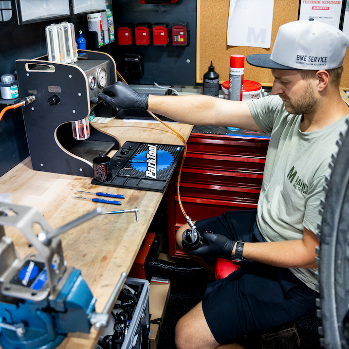 Foto: Laura Kraehe. Person working on a vehicle repair inside a van with tools and equipment.
