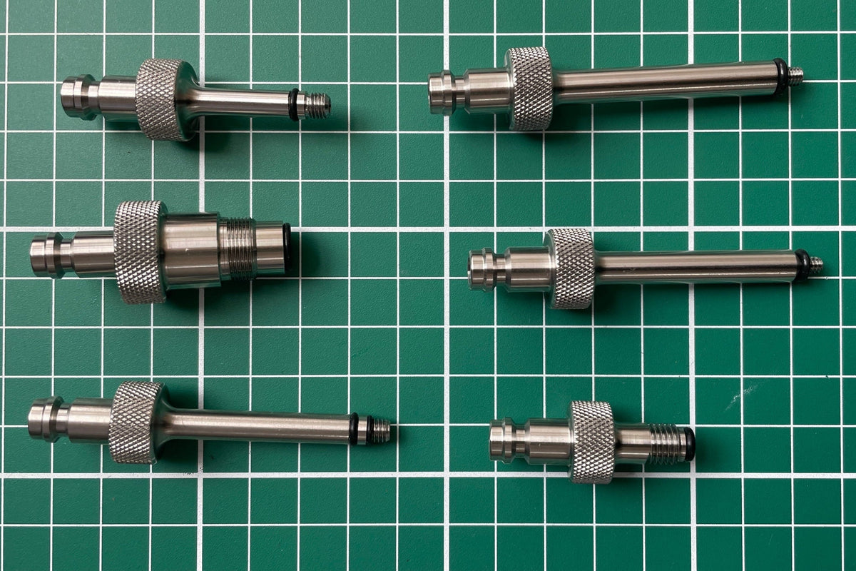 FLI Bleeding adapter: Set of six stainless steel components on a green grid background