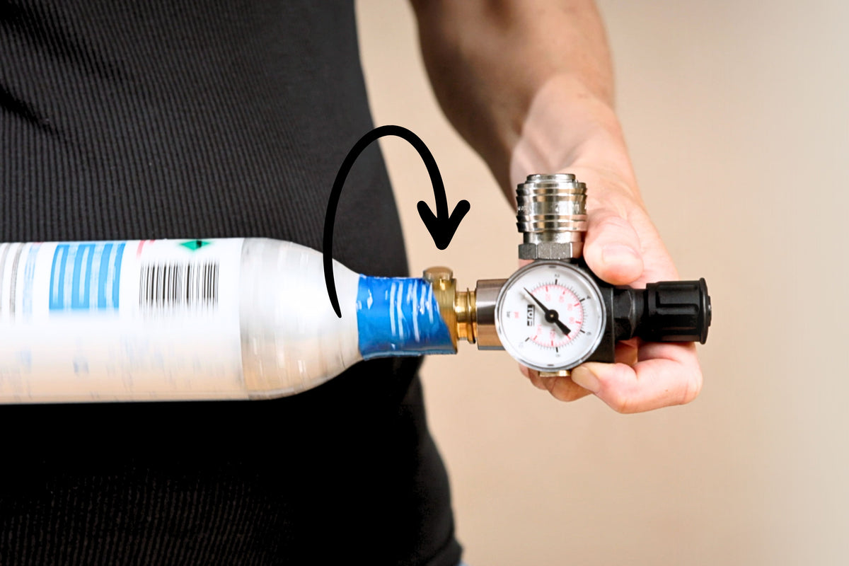 Person showing how to screw pressure adapter on a CO2 bottle for the FLI Venturi